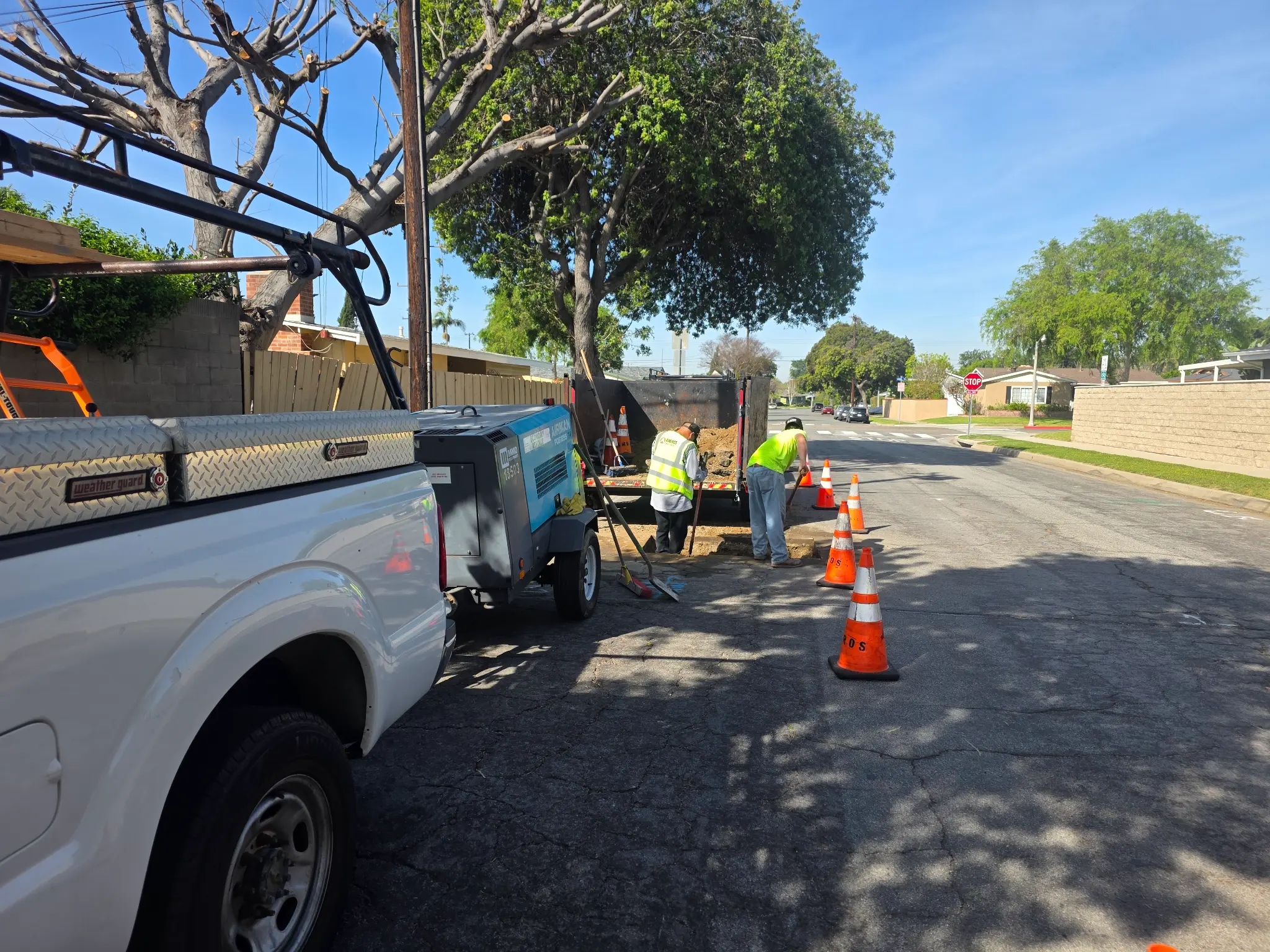 Right-of-way utility work in progress with an Ambros field crew, work truck, and traffic cones